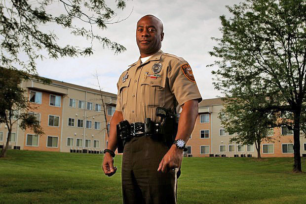 Police Officer Kevin Minor standing in front of the apartment building where he saved a man from a fire. Kevin was featured in the St. Louis Post Dispatch newspaper titled "Heroes."